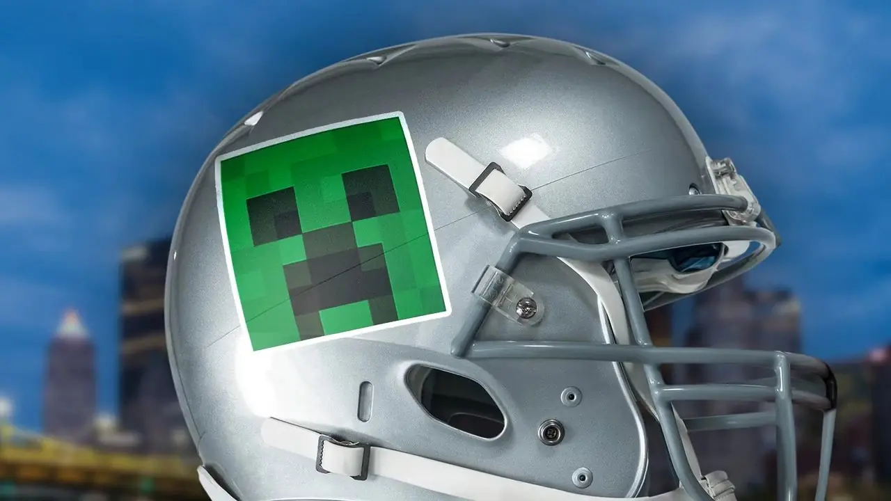 Um capacete de futebol cinza com um decalque de um Creeper do Minecraft colado na lateral.