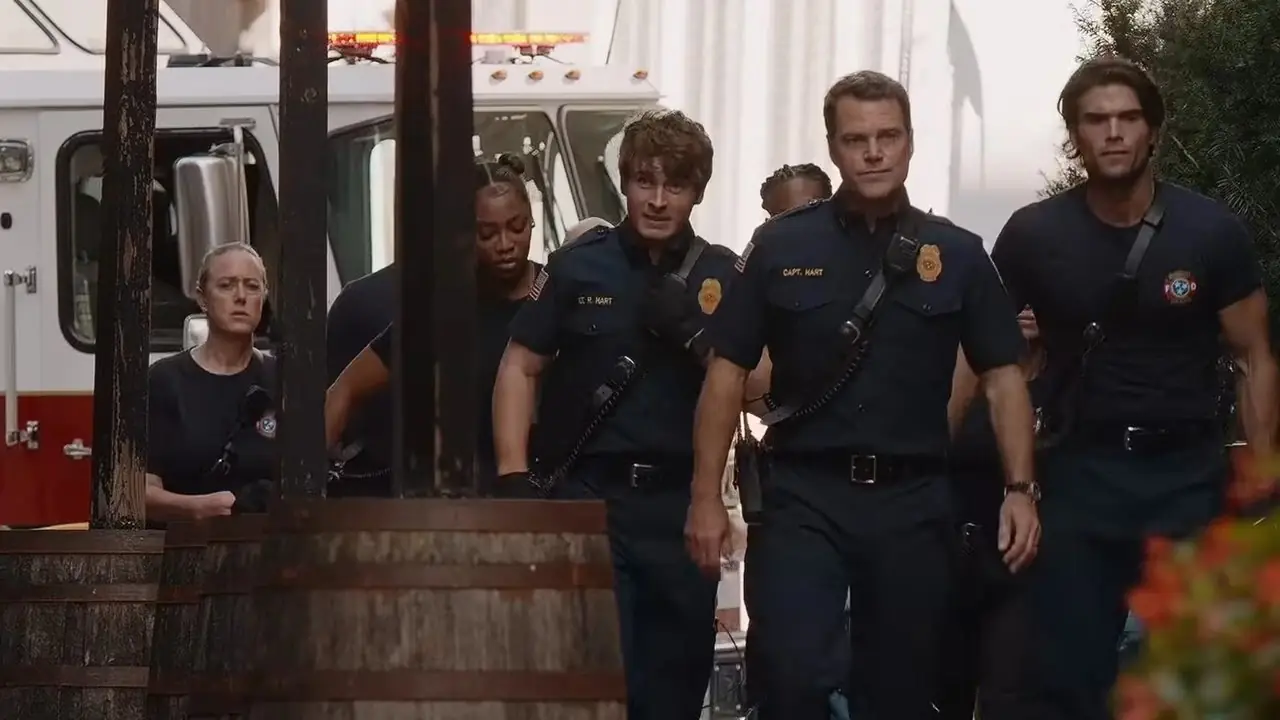 Image promotionnelle pour le 9-1-1 : Nashville montrant un groupe de pompiers et d'autres personnages se tenant ensemble dans une rue de la ville sous un coucher de soleil spectaculaire.