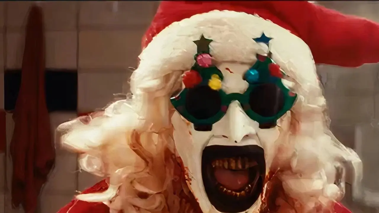Art the Clown sonriendo con las manos levantadas y cubierto de sangre de Terrifier 3